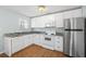 Modern white kitchen with granite countertops and stainless steel appliances at 19718 Gulf Blvd, Indian Shores, FL 33785