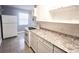 Well-lit kitchen with white cabinets, granite countertops, and a window at 8735 Cristobal Ave, North Port, FL 34287