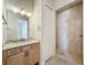 Bathroom boasts a walk-in shower and granite countertops with light wood cabinets at 949 Symphony Isles Blvd, Apollo Beach, FL 33572