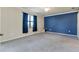 Large bedroom with gray carpet, blue accent wall and balcony access at 20180 Ragazza Cir # 201, Venice, FL 34293