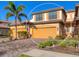 Charming two-story home with a two-car garage, beautiful landscaping, and a brick driveway with a palm tree at 20180 Ragazza Cir # 201, Venice, FL 34293