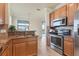 Modern kitchen with granite countertops, wood cabinets, and stainless steel appliances at 20180 Ragazza Cir # 201, Venice, FL 34293