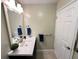 Clean bathroom with a dark vanity, white sink, and white door at 3063 E Dorchester Dr, Palm Harbor, FL 34684