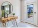 Bright and airy entryway with wood console table and large round mirror at 33438 Colburn Creek Way, Wesley Chapel, FL 33545