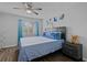 Cozy bedroom with ceiling fan, window, and blue bedding at 10265 Gandy N Blvd # 1002, St Petersburg, FL 33702