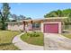 Brick ranch house with a red garage door and landscaped yard at 404 E Morgan St, Brandon, FL 33510