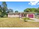 Brick ranch house with a red garage door and landscaped yard at 404 E Morgan St, Brandon, FL 33510