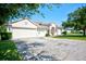 House exterior showcasing a two-car garage and a neatly kept lawn at 13267 Linzia Ln, Spring Hill, FL 34609