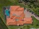 Aerial view of a house with an orange tile roof, a screened pool, and an outside area at 3418 Braeside Pl, Clearwater, FL 33759