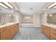 An expansive bathroom features dual vanities, a soaking tub, and elegant chandelier lighting at 3418 Braeside Pl, Clearwater, FL 33759