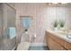 Bathroom featuring unique patterned wallpaper, a walk-in shower, and a light wood vanity at 3418 Braeside Pl, Clearwater, FL 33759