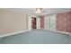 Spacious bedroom featuring patterned wallpaper, white trim, neutral carpet, and an opening to the next room at 3418 Braeside Pl, Clearwater, FL 33759