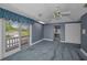 Spacious bedroom with blue carpet, ensuite bath and private balcony access with great natural light at 3418 Braeside Pl, Clearwater, FL 33759