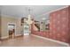 Charming dining room featuring red wallpaper, a chandelier, and views of the foyer at 3418 Braeside Pl, Clearwater, FL 33759