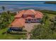 Stunning waterfront property with a clay tile roof, lush landscaping, and a spacious driveway at 3418 Braeside Pl, Clearwater, FL 33759