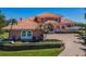 Charming home with a clay tile roof, arched windows, and lush green lawn at 3418 Braeside Pl, Clearwater, FL 33759