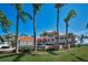 Stunning Mediterranean-style home with a clay tile roof, multiple palm trees, and a well-manicured lawn at 3418 Braeside Pl, Clearwater, FL 33759