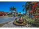 Beautiful entrance to this house featuring vibrant flowers, tropical plants, a pineapple fountain, and a brick driveway at 3418 Braeside Pl, Clearwater, FL 33759