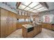 Spacious kitchen featuring wood cabinetry, center island, and unique coffered light fixture at 3418 Braeside Pl, Clearwater, FL 33759