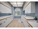 Well-lit laundry room with tile floor, ample cabinets, counter space, and modern appliances at 3418 Braeside Pl, Clearwater, FL 33759