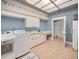 Bright laundry room with tile floor, ample cabinets, counter space, modern appliances, and skylight at 3418 Braeside Pl, Clearwater, FL 33759