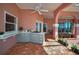 Covered outdoor kitchen with gray cabinets, tile flooring, bar sink and cooking surface at 3418 Braeside Pl, Clearwater, FL 33759