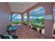 Spacious covered patio featuring tiled floors, columns, seating and a screened-in pool with water views at 3418 Braeside Pl, Clearwater, FL 33759