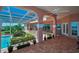 Elegant patio features a brick floor, arched columns, and a screened pool area overlooking a serene water view at 3418 Braeside Pl, Clearwater, FL 33759