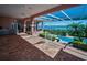 Expansive patio featuring brick flooring, a screened pool, beautiful landscaping and a serene waterfront view at 3418 Braeside Pl, Clearwater, FL 33759