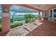 Spacious patio boasts brick flooring, arched details, access to a screened pool area, and stunning water views at 3418 Braeside Pl, Clearwater, FL 33759