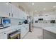 Bright kitchen with white cabinets, granite counters, and stainless steel appliances at 13267 Linzia Ln, Spring Hill, FL 34609