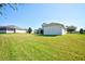 Landscaped backyard with a grassy area and neighboring homes at 13267 Linzia Ln, Spring Hill, FL 34609