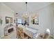 Elegant dining room with a rustic table, view into living room, and chandelier at 13267 Linzia Ln, Spring Hill, FL 34609