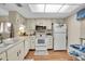 Bright kitchen features white cabinets, and a breakfast nook at 12400 Dearborn Dr # F, Hudson, FL 34667