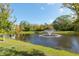 Community pond with fountain and lush landscaping at 10038 Corso Milano Dr, Tampa, FL 33625