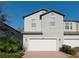 Two-story house with white garage door and brick driveway at 10038 Corso Milano Dr, Tampa, FL 33625