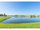 Tranquil lake view with houses in background, ideal for a relaxing community setting at 1810 Raven Glen Dr, Ruskin, FL 33570