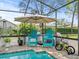 Relaxing poolside seating with two teal chairs and a small bike at 14173 Pullman Dr, Spring Hill, FL 34609