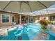 Inviting pool area with patio furniture, umbrella, and lush landscaping at 14173 Pullman Dr, Spring Hill, FL 34609