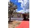 Charming home featuring tan siding, bright red shutters, and a covered carport, offering both style and practicality at 36822 Kay Ave, Zephyrhills, FL 33542