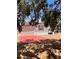 Exterior of home with red patio and red shuttered window under shade of trees at 36822 Kay Ave, Zephyrhills, FL 33542