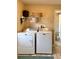 Functional laundry room with modern washer and dryer and overhead storage at 36822 Kay Ave, Zephyrhills, FL 33542