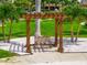 Inviting outdoor seating area with a wooden pergola, bench, and serene landscaping at 5200 Brittany S Dr # 1202, St Petersburg, FL 33715