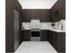 Modern kitchen with dark cabinetry, marble backsplash, and stainless steel appliances at 1076 Snell Isle Ne Blvd, St Petersburg, FL 33704
