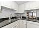 Modern kitchen with white cabinets, black countertops, and stainless steel appliances at 1540 Glen Oaks E Dr # B134, Sarasota, FL 34232