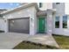 Modern home's front entry with green door and gray garage at 3119 W Cypress St, Tampa, FL 33607