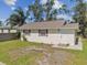 Single-story home with white siding, red accents, and a small deck at 132 Dartmouth W Ave, Oldsmar, FL 34677