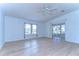 Living room with wood-look floors, large windows, and sliding glass doors at 37608 Lorena Ave, Zephyrhills, FL 33541