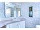 Bathroom with vanity, medicine cabinet and patterned wallpaper at 37608 Lorena Ave, Zephyrhills, FL 33541