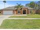 Single-story home with two-car garage and landscaped yard at 14173 Pullman Dr, Spring Hill, FL 34609